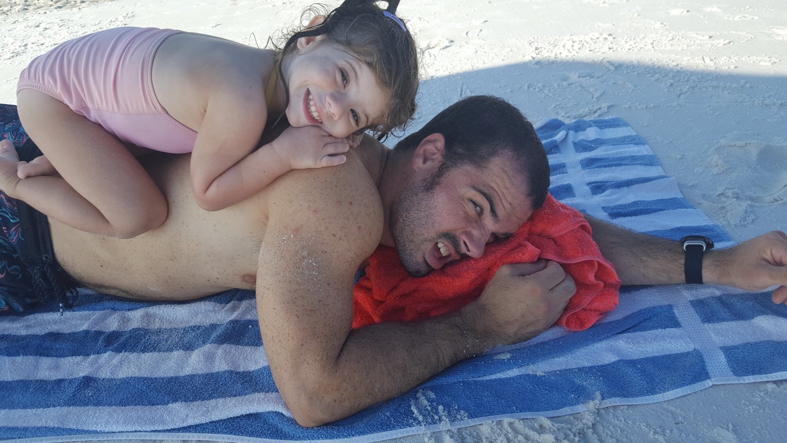 Cole and his daughter laughing together at the beach